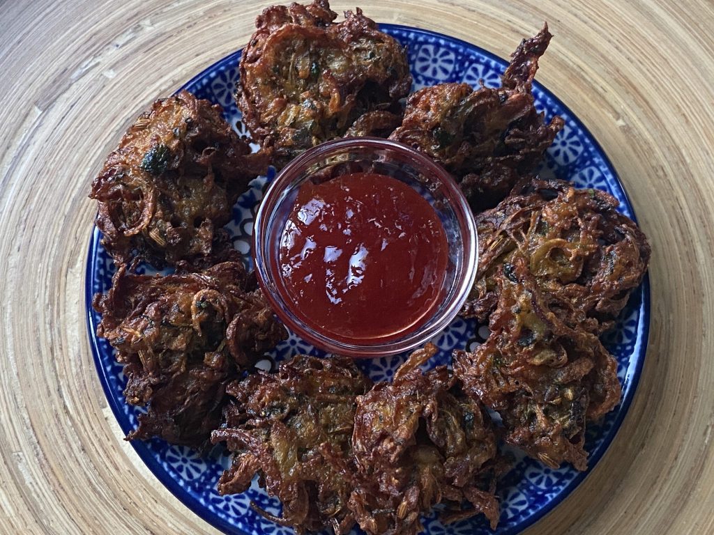 Bord met kanda bhaji en rode saus