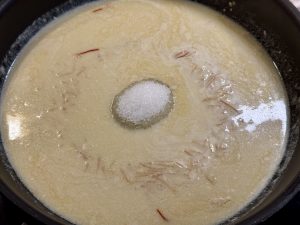 amandelmelk, saffraan, vermicelli en suiker in een hapjespan aan de kook