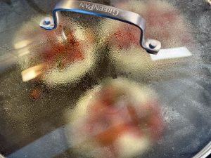 Uttapams in de pan, met de deksel erop