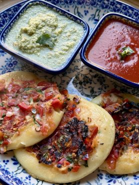 Bord met 3 uttapams, tomatensaus en een friszure kokoschutney