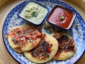 Bord met 3 uttapams, tomatensaus en een friszure kokoschutney