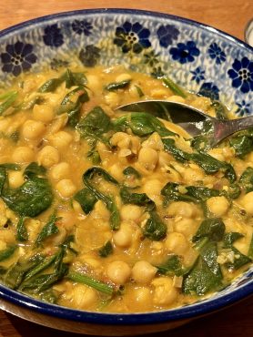 Een Bunzlau schaaltje gevuld met chana saag -kikkererwten en spinazie- en een klein stukje van een bakje munt-raita