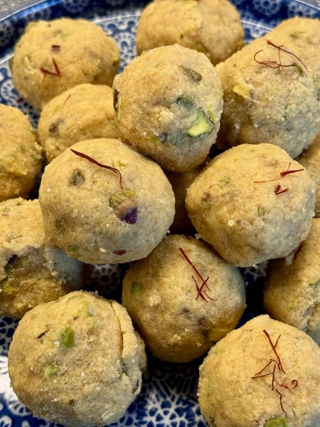 Bunzlau bord met opstaande rand, gevuld met besan pista ladoo (zoete balletjes van kikkererwtenmeel met pistachenoten)