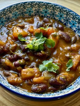 Een bunzlau schaaltje vol met rajma masala, een Indiaas kidneygerecht in kruidige saus