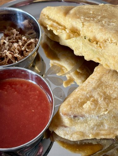 Gefrituurde gevulde sandwiches met tomatensaus en gebakken uitjes