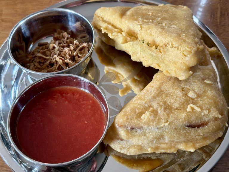 Gefrituurde gevulde sandwiches met tomatensaus en gebakken uitjes