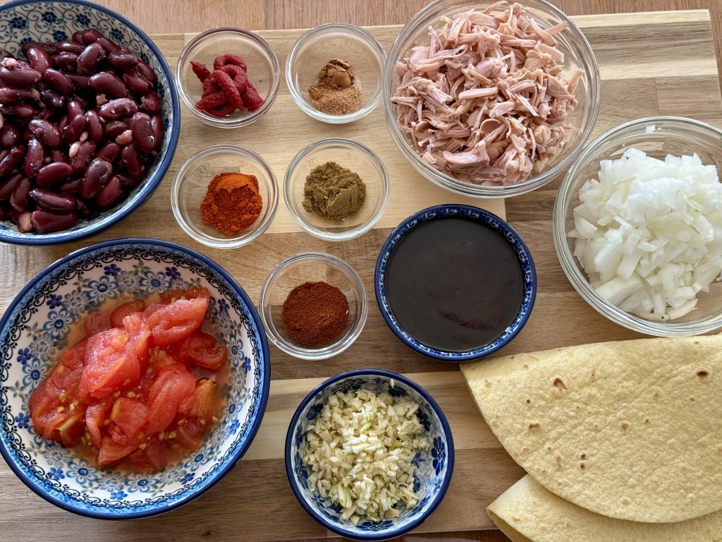 Ingrediënten voor een taco bowl, alles op een grote snijplank