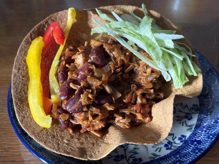 Bunzlau bord met daarop een tortillabakje, heerlijke vulling en ijsbergsla met paprika