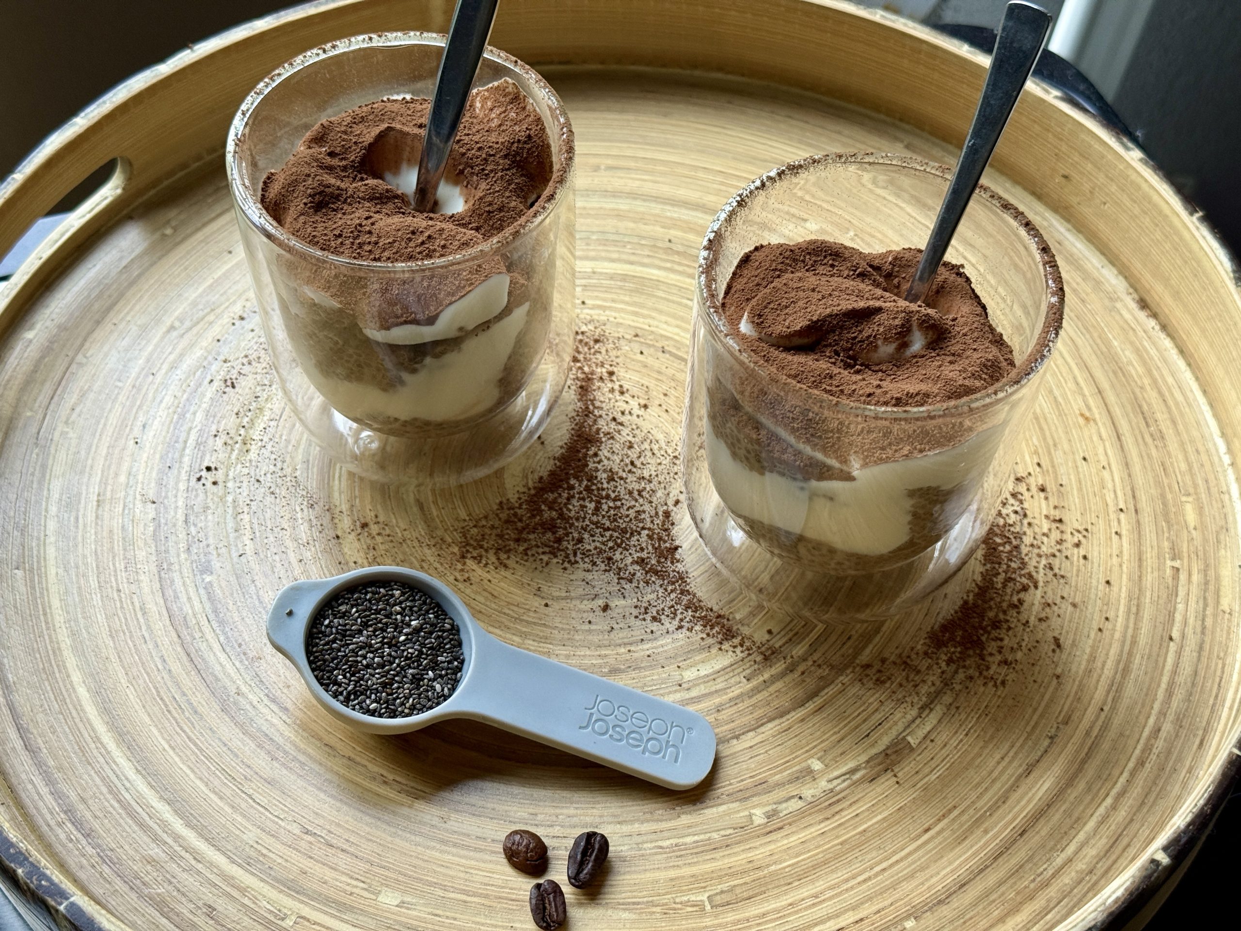 Twee glazen met chiamisu, een lepel chiazaad en wat koffiebonen