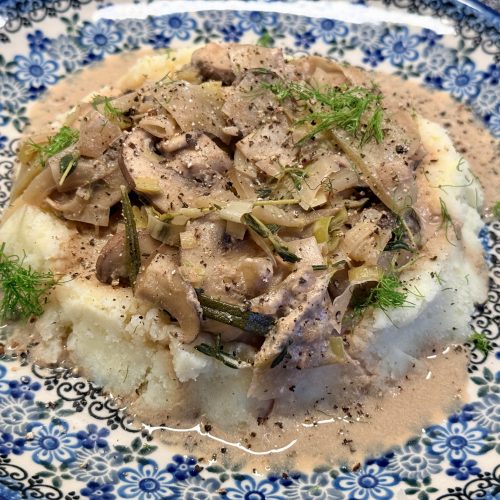 Romige venkel-paddenstoelen stoofpot met aardappelpuree, op een Bunzlau bord