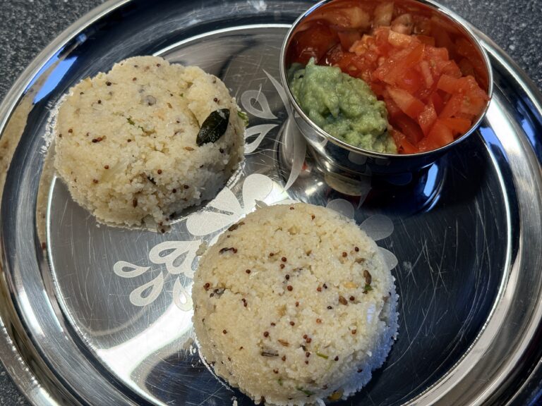 RVS bord met daarop 2 bolletjes upma rava, tomatenblokjes en kokoschutney